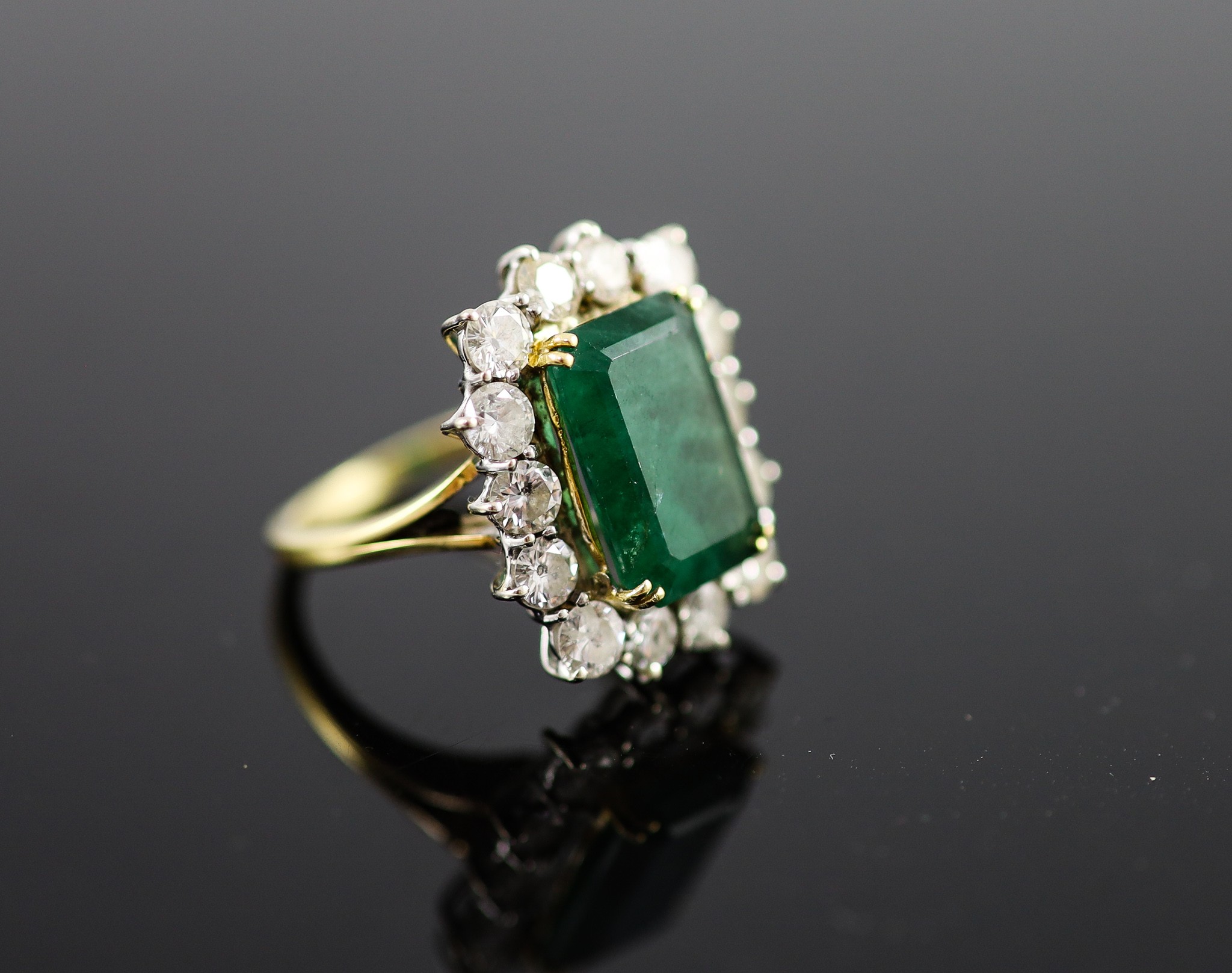 A mid to late 20th century 18ct gold, emerald and diamond set shaped rectangular cluster ring
